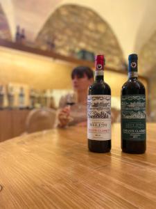 
two bottles of wine sit on a wooden table at Castello Di Meleto Wine Destination - Camere in Castello e Appartamenti in Gaiole in Chianti

