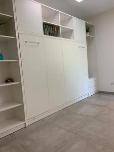 ein leeres Zimmer mit weißen Schränken und Regalen in der Unterkunft Firmen & Ferienwohnung Brecht 2 in Waibstadt