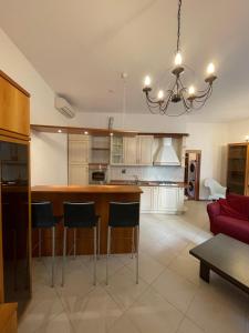 cocina con barra y sofá rojo en Trionfo your home in Trieste business and holiday stays en Trieste