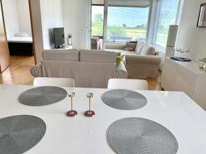 ein Wohnzimmer mit einem weißen Tisch und Stühlen in der Unterkunft Papli Seaview Apartment in Pärnu