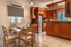 a kitchen with a table and chairs and a refrigerator at Eleni's Seaview House in Andros