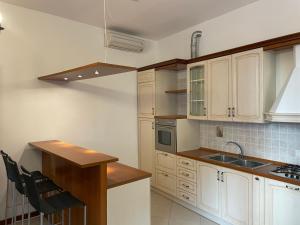 una cocina con armarios blancos y fregadero en Trionfo your home in Trieste business and holiday stays en Trieste