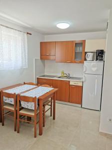 Apartment Sara في نجيفيش: مطبخ صغير مع طاولة وثلاجة