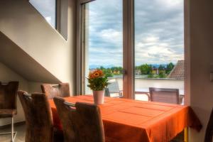 Alpenblick 3 في Lindau-Bodolz: طاولة غرفة الطعام مع إناء من الزهور عليها