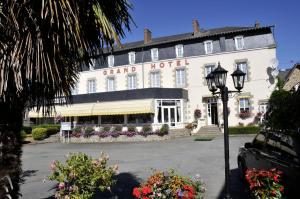 un grand hôtel avec un éclairage de rue devant lui dans l'établissement Logis Au Grand Hotel, à Mayenne