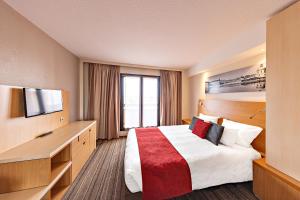 图卢兹Aparthotel Adagio Toulouse Centre Ramblas的一间配有床和平板电视的酒店房间