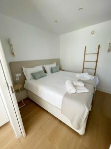 sypialnia z dużym białym łóżkiem z dwiema poduszkami w obiekcie Oasis Beach Apartment w Corralejo +21 zdjęć