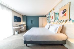 - une chambre avec un grand lit et un bureau dans l'établissement Ilot du Golf BW Premier Collection, à Mandelieu-la-Napoule