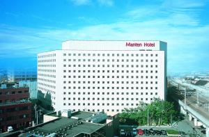Kanazawa Manten Hotel Ekimae في كانازاوا: مبنى ابيض عليه علامة فندق مريخي