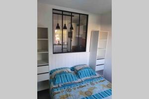 a bedroom with a bed and a mirror at Colibri Appart' T2 au coeur du Bassin d'Arcachon in Gujan-Mestras