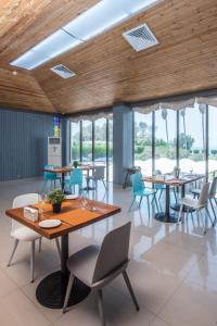 a dining room with tables and chairs and windows at BM Beach Hotel in Ras al Khaimah