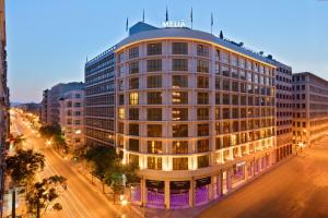 ein großes Gebäude in der Nacht auf einer Stadtstraße in der Unterkunft Melia Athens in Athen