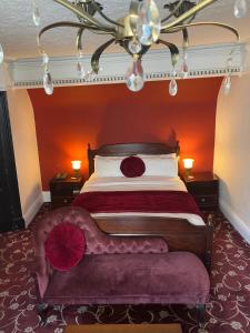 
a bed room with a red bedspread and pillows at The Tudor Hotel in Bridgwater
