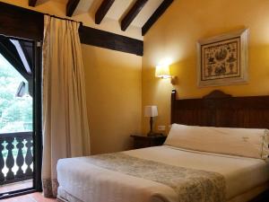 ein Schlafzimmer mit einem Bett und einem großen Fenster in der Unterkunft Hotel Rebeco in Fuente Dé