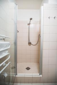 um chuveiro com uma porta de vidro na casa de banho em Stacja Nowa Gdynia Bed & Breakfast em Lódź
