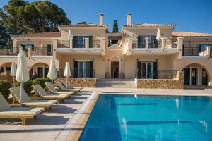 a villa with a swimming pool in front of a house at Aegean Villas in Poros