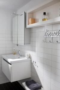 a white bathroom with a sink and a mirror at Vakantiehuis Olivia in Schoorl +22 photos