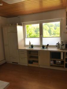 a kitchen with white cabinets and two windows at Ferienhaus Anita am Radweg in Hornbach