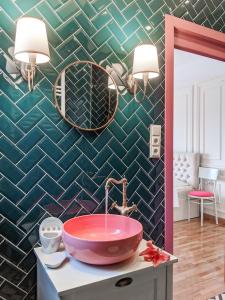 uma casa de banho com um lavatório rosa e um espelho. em Boutique Apartment - Signature em Kutaisi