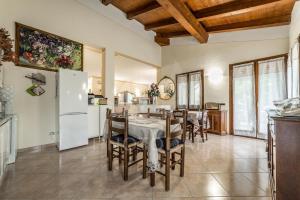 una cucina e una sala da pranzo con tavolo e frigorifero di Villa Paselli a Rioveggio