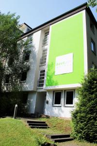un edificio verde con un cartel en el costado en Rheinsteig Quartier by bestprice Hotels en Bendorf