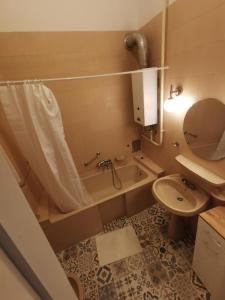 uma casa de banho com uma banheira, um lavatório e um WC. em Antikvilla Apartman em Szeged