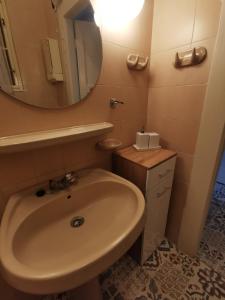 a bathroom with a sink and a mirror at Antikvilla Apartman in Szeged