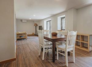 a dining room with a table and white chairs at Casa Velha de Ponta Sôto in Cela