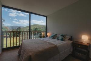 a bedroom with a bed and a large window at Casa Velha de Ponta Sôto in Cela +24 photos