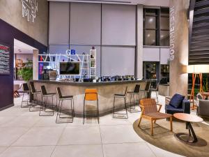 een lobby met een bar met stoelen en tafels bij Novotel Sorocaba in Sorocaba