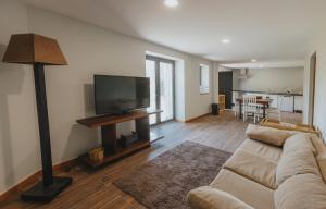 a living room with a couch and a flat screen tv at Casa Velha de Ponta Sôto in Cela