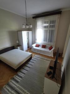 a living room with two beds and a table at Antikvilla Apartman in Szeged