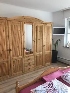 Zimmer mit einem großen Holzschrank und einem Spiegel in der Unterkunft Ferienhaus Anita am Radweg in Hornbach
