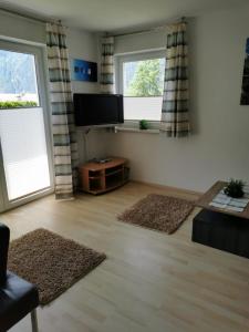 ein Wohnzimmer mit 2 Fenstern und einem Flachbild-TV in der Unterkunft Haus Matthias in Umhausen