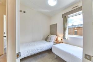 two beds in a small room with a window at Host & Stay - Yolo Lodge in Felton