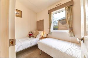 two beds in a small room with a window at Host & Stay - Yolo Lodge in Felton +9 photos
