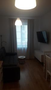 a living room with a couch and a flat screen tv at Apartamenty Irena Stare Miasto Św. Ducha in Elblag