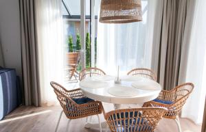 a white table and chairs in a room with a window at Amber-Blue Palanga in Palanga