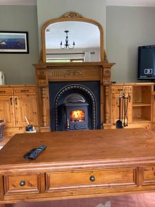 a living room with a fireplace and a wooden coffee table at Eagles Lodge in Killarney