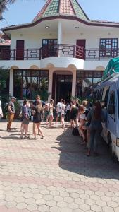 um grupo de pessoas andando em frente a um edifício em New Charity Hotel International em Arusha