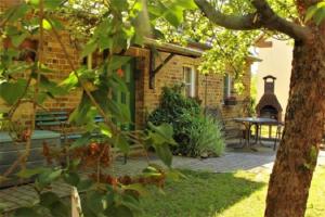 a brick house with a green door and a patio at Bauernhof Ladusch in Kolonie Baruther Berg