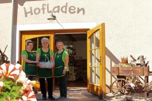 Tres mujeres están frente a una tienda. en Bauernhof Ladusch en Kolonie Baruther Berg
