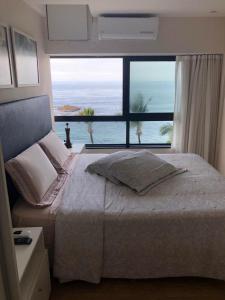 1 dormitorio con cama grande y ventana grande en Maravilhoso apartamento 2 quartos vista mar no Ondina Apart, en Salvador