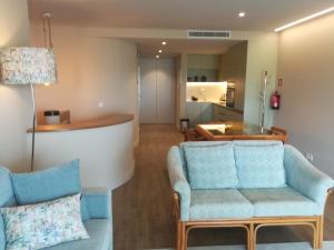 a living room with two blue chairs and a table at Victory Village 16F in Quinta do Lago
