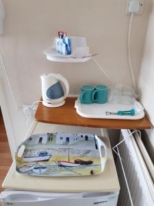 a shelf in a refrigerator with cups and appliances at Sunnyside Hotel in Great Yarmouth