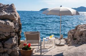 a table and a chair and an umbrella on the beach at 5 Bedroom Villa with Private Pool in Poljice