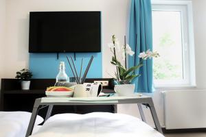 a living room with a table with a tv on the wall at Koblenz Valley Hotel by Belvilla in Bendorf