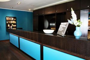 a bar in a restaurant with a blue wall at besttime Hotel Bendorf Koblenz in Bendorf