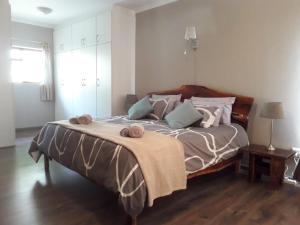 a bedroom with a large bed with pillows on it at Leisure@Loerie in Sedgefield