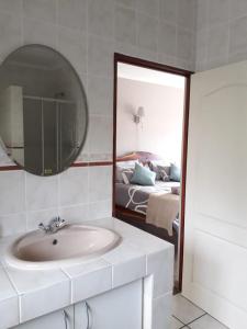 een badkamer met een wastafel, een spiegel en een bed bij Leisure@Loerie in Sedgefield